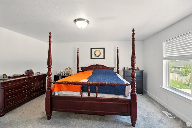 bedroom with light carpet and baseboards