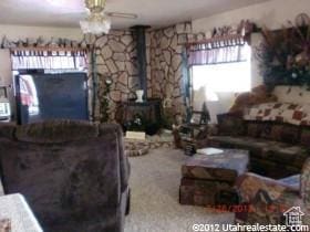 living area with a wood stove and carpet flooring