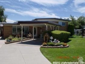 tri-level home with driveway and a front lawn
