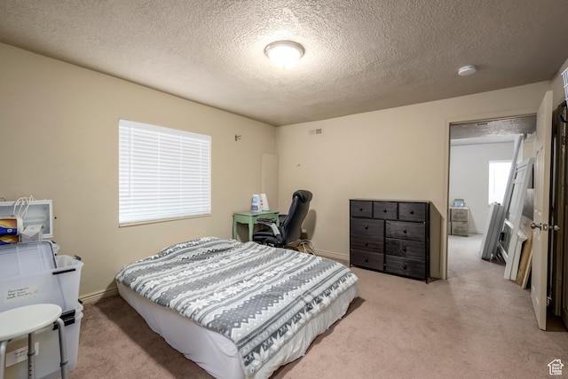 bedroom featuring a textured ceiling, light carpet, and baseboards