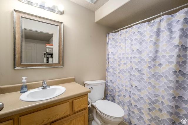 bathroom with toilet, vanity, a textured ceiling, and curtained shower