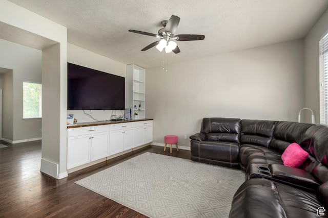 living room featuring a ceiling fan, dark wood-type flooring, baseboards, and plenty of natural light