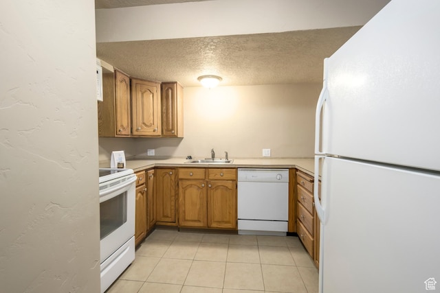 kitchen featuring white appliances, a textured ceiling, a sink, brown cabinets, and light countertops