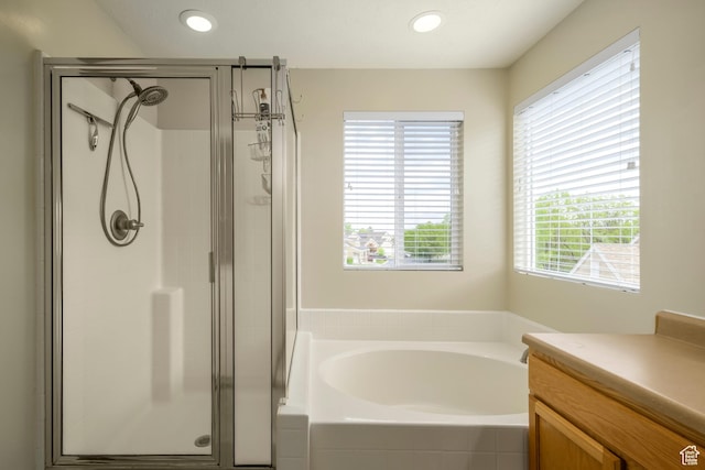 full bath featuring a shower stall, a garden tub, recessed lighting, and vanity