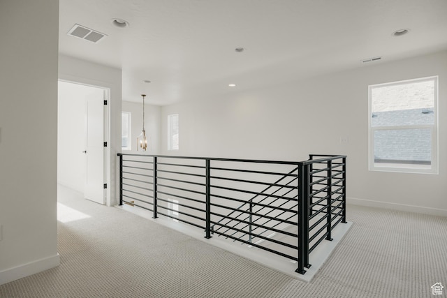 hall featuring carpet floors, an upstairs landing, baseboards, plenty of natural light, and recessed lighting