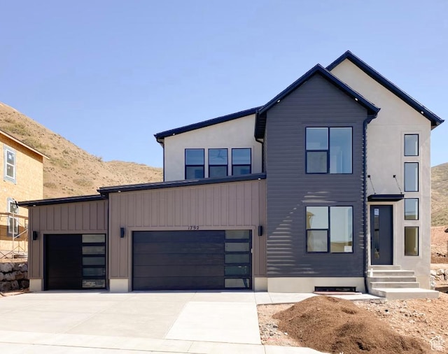 contemporary home with a garage, concrete driveway, and a mountain view