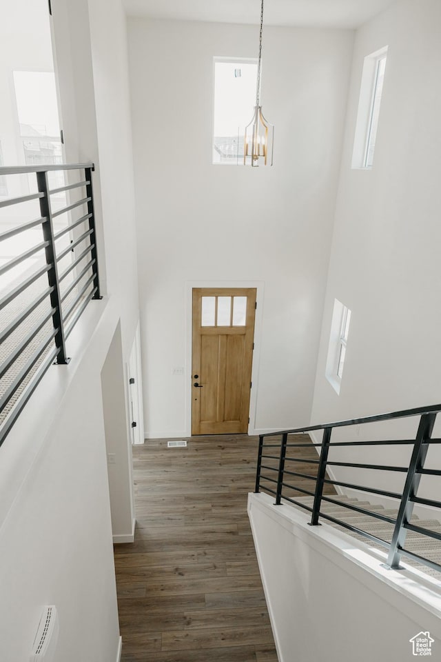 entrance foyer featuring a high ceiling, a chandelier, dark wood-style floors, and healthy amount of natural light