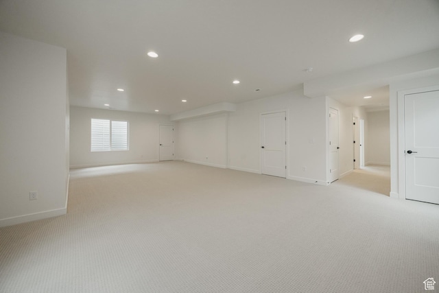 basement featuring recessed lighting, baseboards, and light carpet