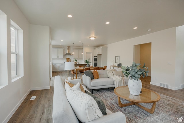 living room featuring light wood-style floors, baseboards, and recessed lighting
