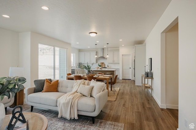 living room with wood finished floors, recessed lighting, and baseboards