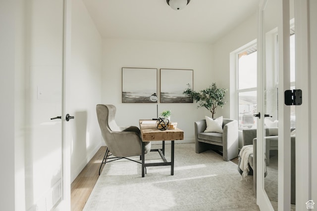 sitting room featuring wood finished floors, french doors, and baseboards