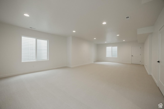unfurnished room featuring recessed lighting, light carpet, and baseboards