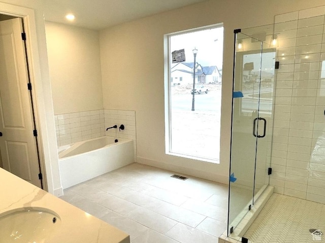 2917 E Liam Ln Unit 107, Eagle Mountain, UT 84005 - bathroom featuring a bath, a stall shower, healthy amount of natural light, tile patterned floors, and recessed lighting