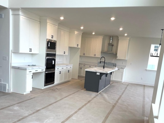 2917 E Liam Ln Unit 107, Eagle Mountain, UT 84005 - kitchen with wall chimney exhaust hood, finished concrete floors, appliances with stainless steel finishes, light countertops, and white cabinetry