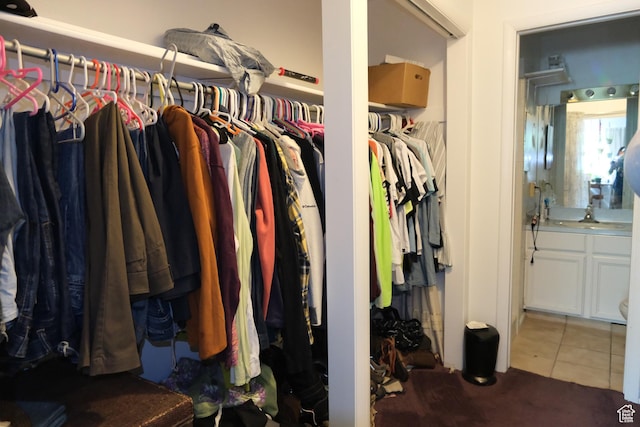 spacious closet featuring tile patterned flooring, a sink, and carpet