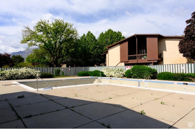 view of pool with fence, a patio, and a mountain view