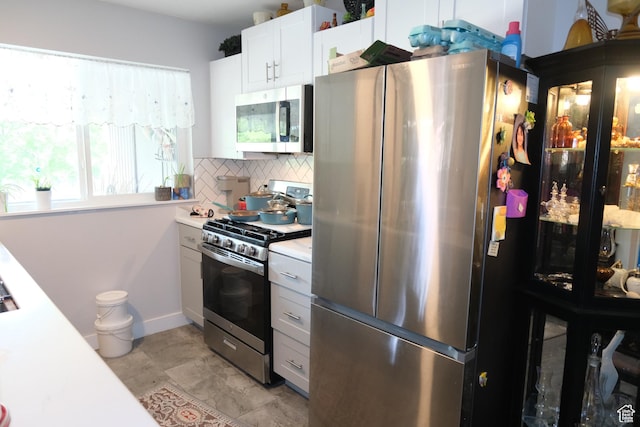 kitchen featuring appliances with stainless steel finishes, tasteful backsplash, light countertops, and white cabinets
