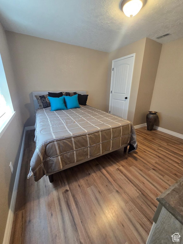 1256 Jefferson Cir, Price, UT 84501 - bedroom featuring baseboards, wood finished floors, and a textured ceiling