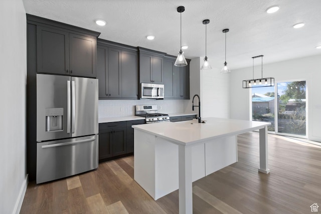 705 N Brooke Ave, Tooele, UT 84074 - kitchen with appliances with stainless steel finishes, a sink, dark wood-style flooring, tasteful backsplash, and light countertops