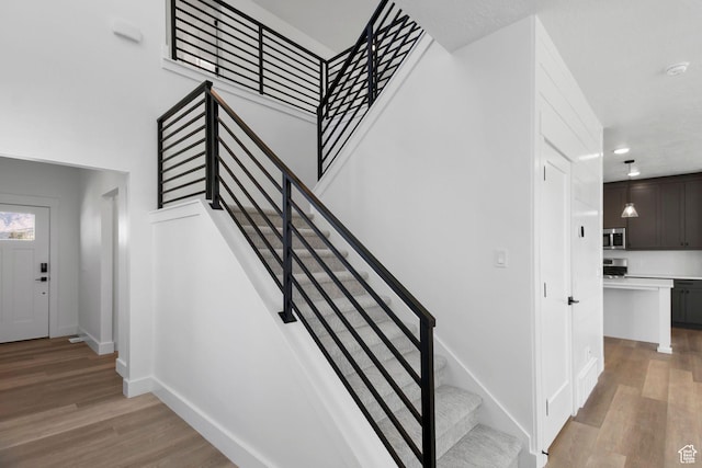 705 N Brooke Ave, Tooele, UT 84074 - staircase with wood finished floors, baseboards, and recessed lighting