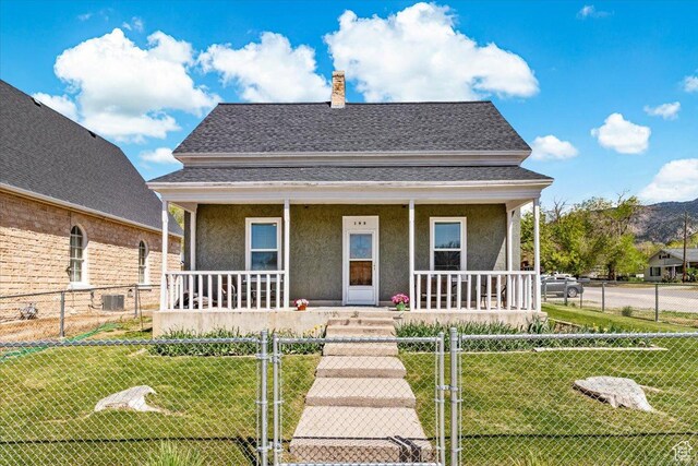 193 S Main E, Manti, UT 84642 - view of front facade with a porch, stucco siding, a chimney, a gate, and a shingled roof
