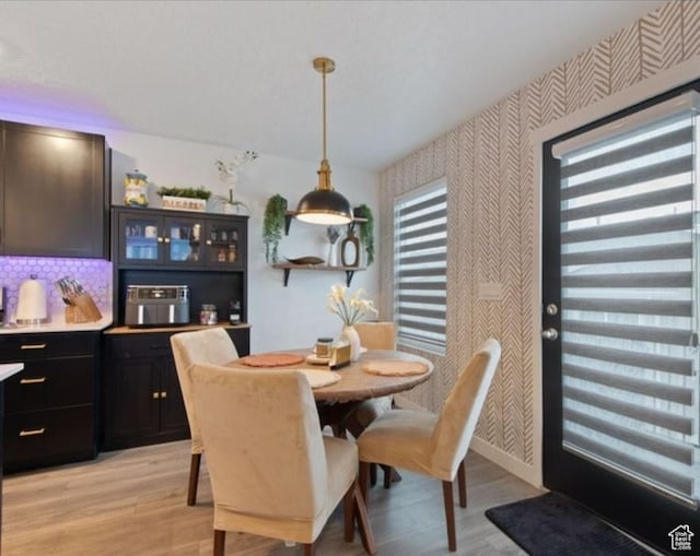 8578 W Bowie Dr, Magna, UT 84044 - dining area with wallpapered walls, light wood-style flooring, and baseboards