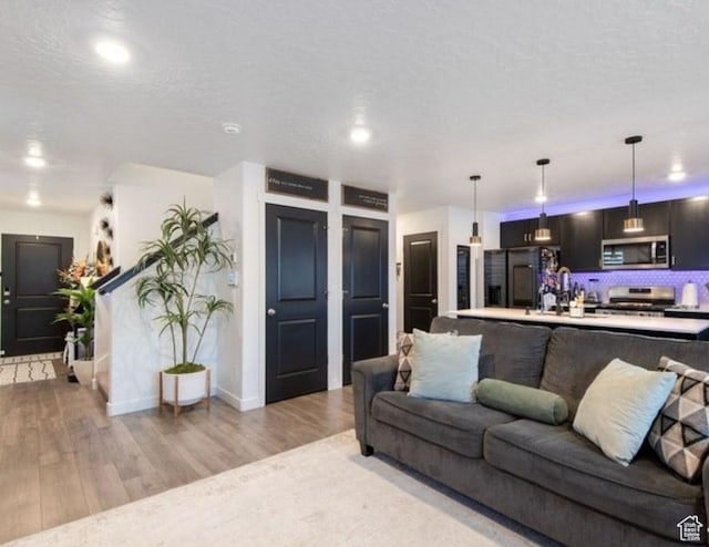 8578 W Bowie Dr, Magna, UT 84044 - living room with light wood finished floors, baseboards, recessed lighting, and a textured ceiling