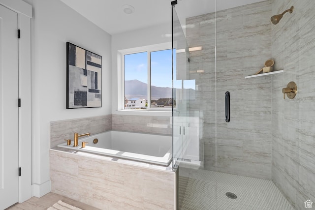 full bath featuring a stall shower, a bath, and a mountain view