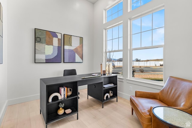 office area with baseboards and light wood-style flooring