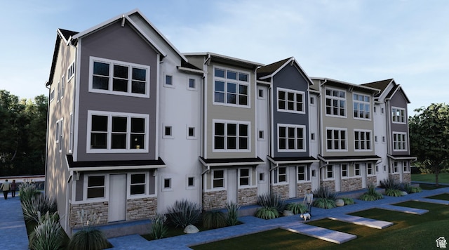 view of front of home featuring stone siding and a front yard
