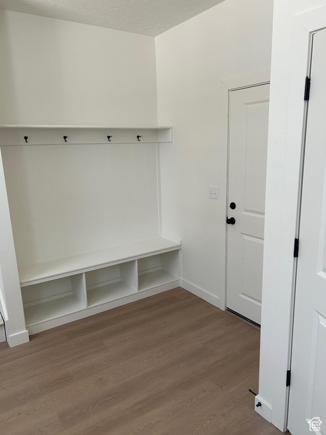 mudroom featuring wood finished floors and baseboards