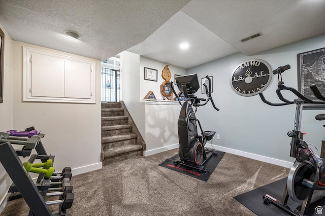 exercise room featuring baseboards and a textured ceiling