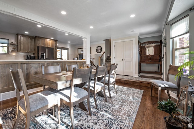 dining space with ornamental molding, plenty of natural light, dark wood-type flooring, and recessed lighting