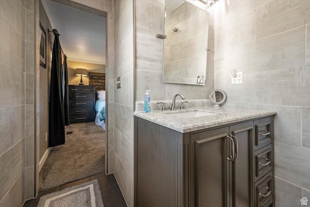 ensuite bathroom with vanity and tile walls