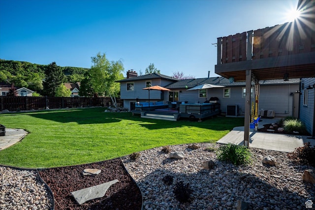 view of yard with a patio area, a wooden deck, and central AC unit
