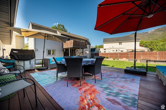 wooden terrace with grilling area, outdoor dining space, and outdoor lounge area