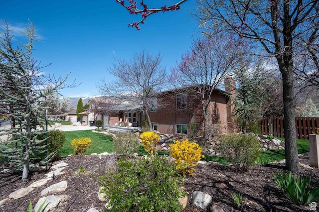 back of property with a chimney and a patio
