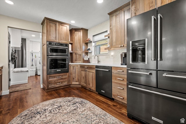 kitchen with high end refrigerator, dishwashing machine, multiple ovens, dark wood-style flooring, and recessed lighting