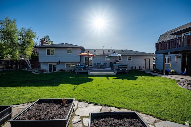 rear view of house featuring a garden, a wooden deck, and a chimney