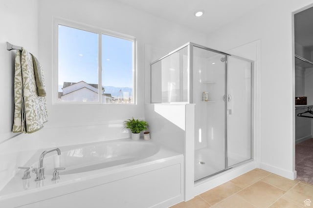 full bathroom with a shower stall, a bath, tile patterned floors, and a spacious closet