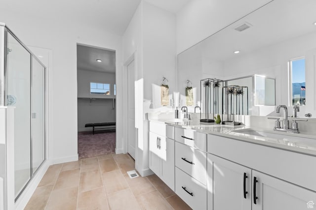 bathroom with a stall shower, double vanity, recessed lighting, a walk in closet, and tile patterned floors