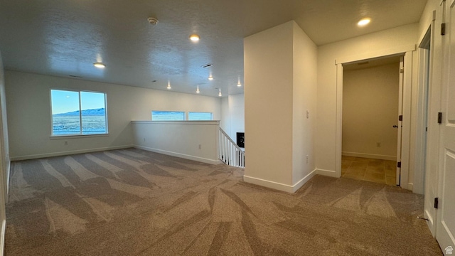 carpeted empty room featuring baseboards and recessed lighting
