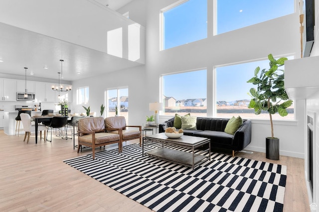 living room with light wood-style flooring, a chandelier, recessed lighting, and baseboards