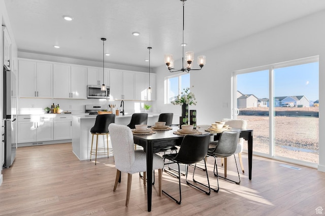 dining room featuring light wood-type flooring, a chandelier, and recessed lighting