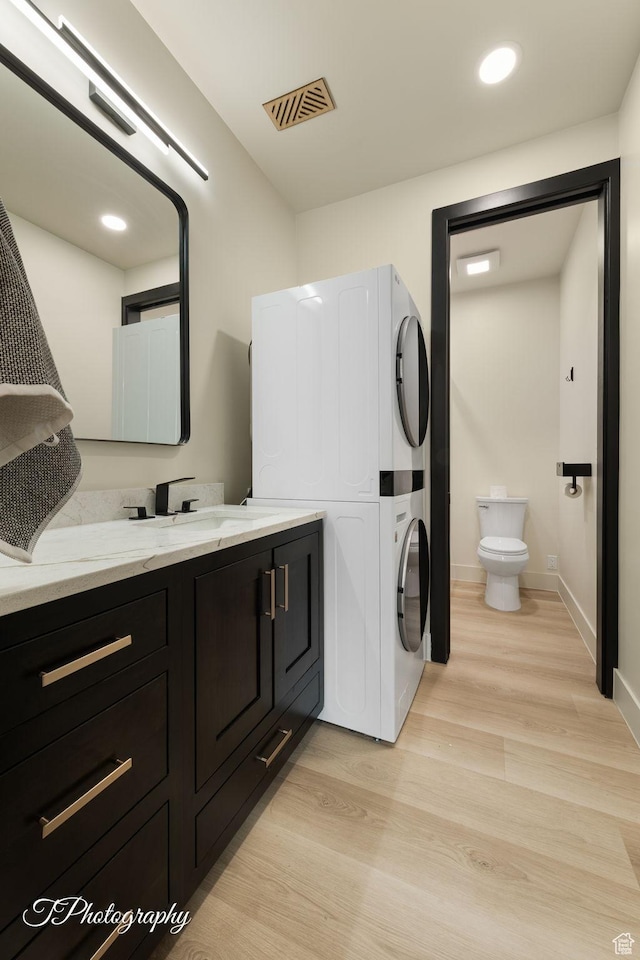 3195 S Tallow Tree Dr, St George, UT 84790 - bathroom featuring stacked washer / dryer, wood finished floors, vanity, and recessed lighting