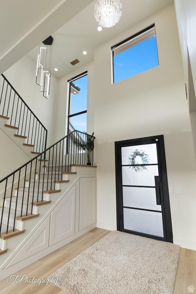 3195 S Tallow Tree Dr, St George, UT 84790 - foyer entrance featuring light wood-type flooring, a high ceiling, a chandelier, stairway, and recessed lighting