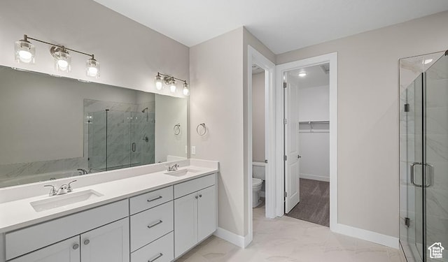full bathroom featuring marble look tiles, a shower stall, toilet, baseboards, and double vanity