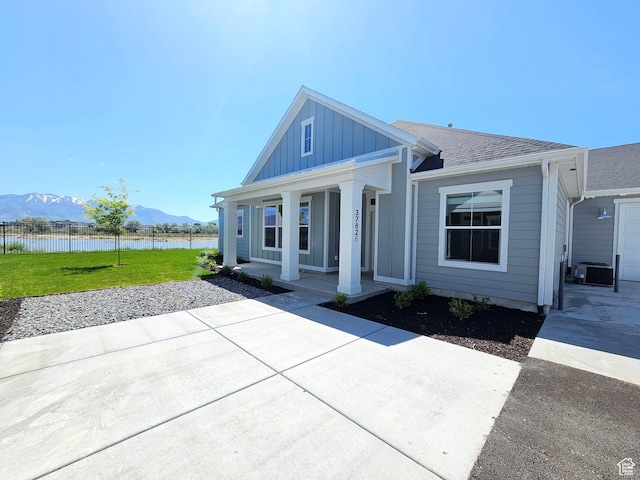 3782 S 4250 W Unit 432B, West Haven, UT 84401 - view of front of property featuring a water and mountain view, board and batten siding, a porch, central AC unit, and roof with shingles
