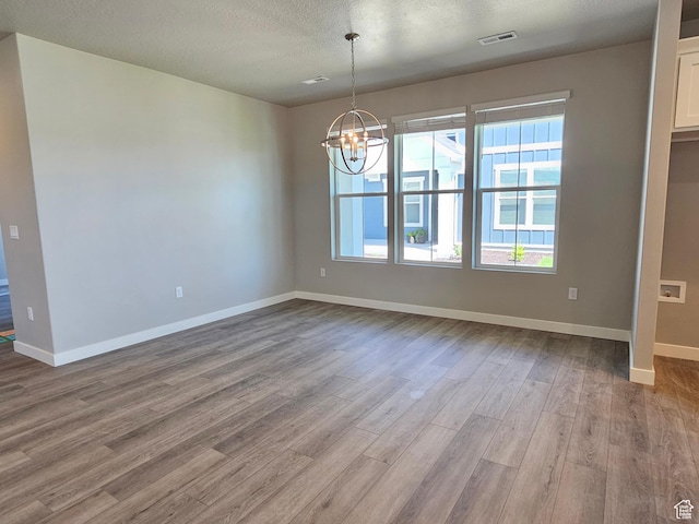3782 S 4250 W Unit 432B, West Haven, UT 84401 - unfurnished dining area featuring wood finished floors, a chandelier, healthy amount of natural light, baseboards, and a textured ceiling