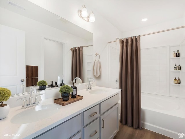 full bathroom with shower / tub combo, double vanity, and wood finished floors